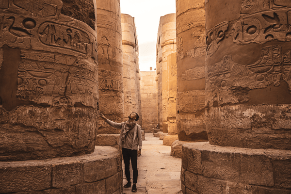 Jeune homme regardant avec les colonnes du temple Karnak à Louxor, en Égypte